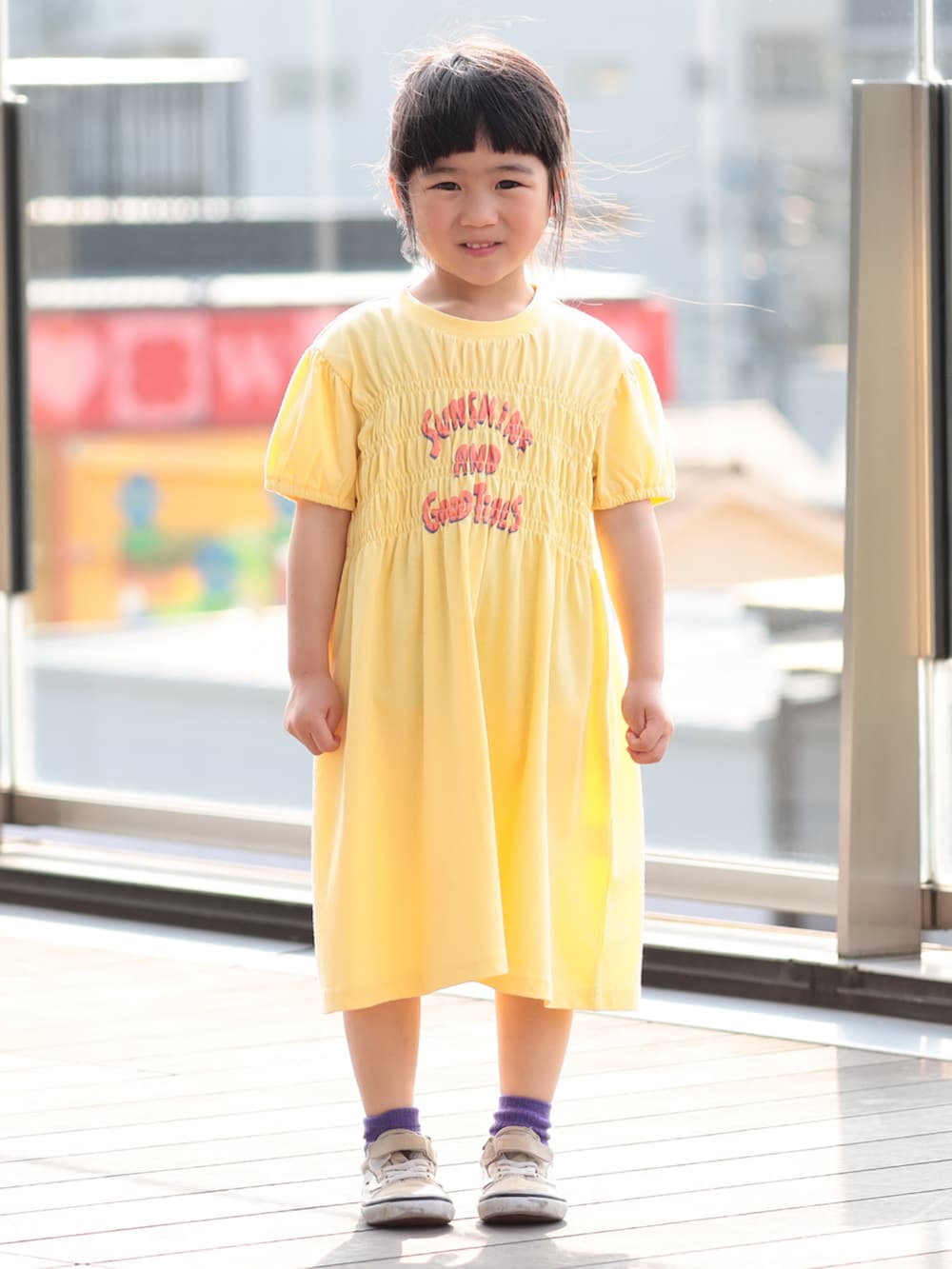 イエロー系のワンピースを着用したキッズの春コーディネートの2枚目の写真