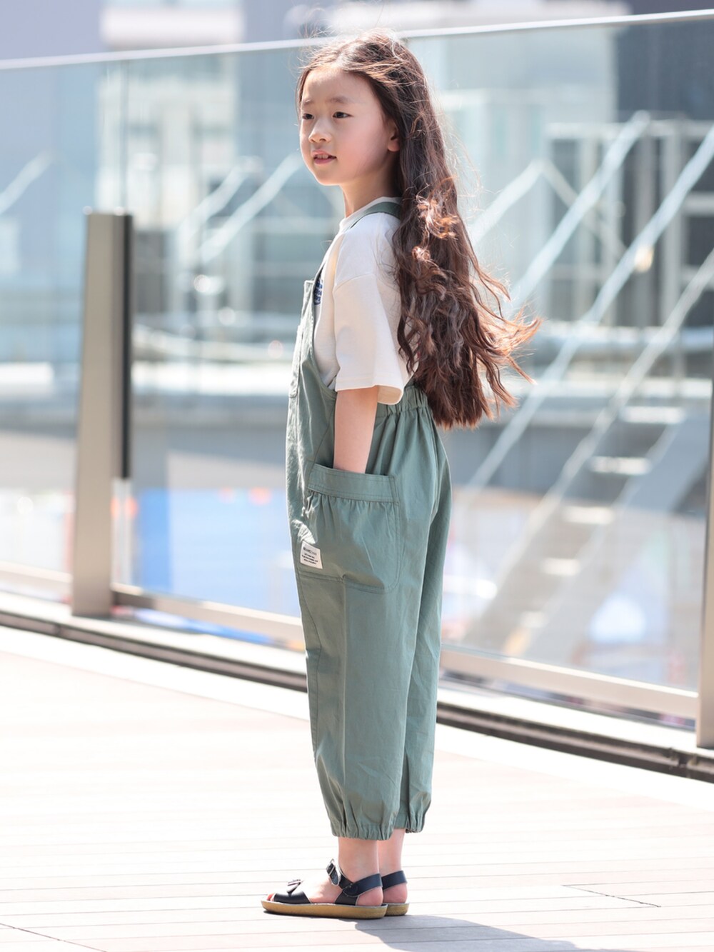 グリーン系のサロペット/オーバーオール、ホワイト系のTシャツ/カットソーを着用したキッズの夏コーディネートの2枚目の写真