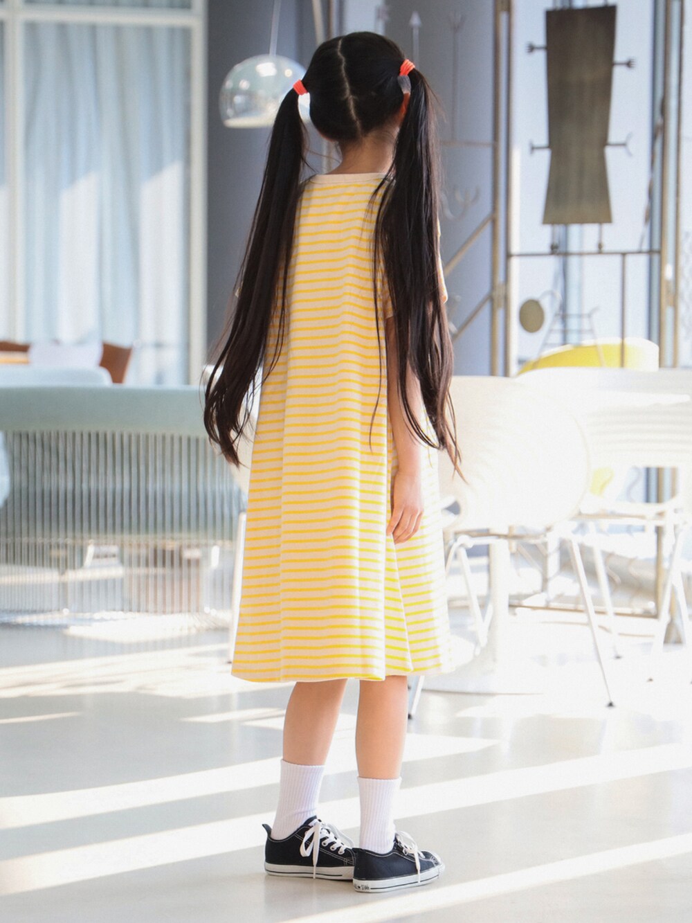 イエロー系のワンピースを着用したキッズの春コーディネートの3枚目の写真