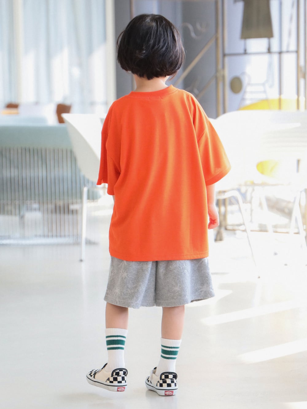 グレー系のその他パンツ、オレンジ系のTシャツ/カットソーを着用したキッズの春コーディネートの2枚目の写真