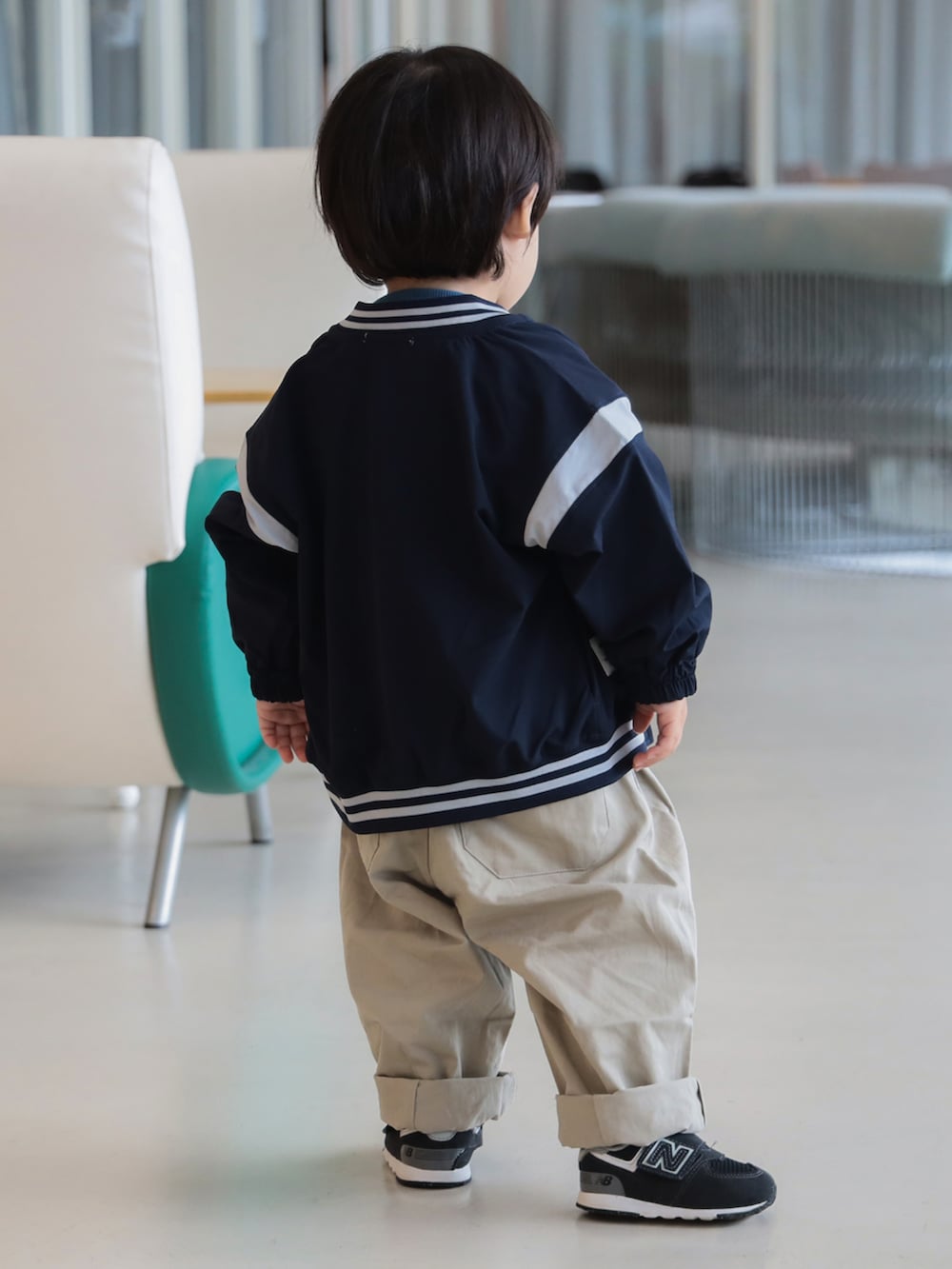 ブルー系のブルゾン、ブルー系のスウェット、ベージュ系のその他パンツを着用したキッズの秋コーディネートの3枚目の写真