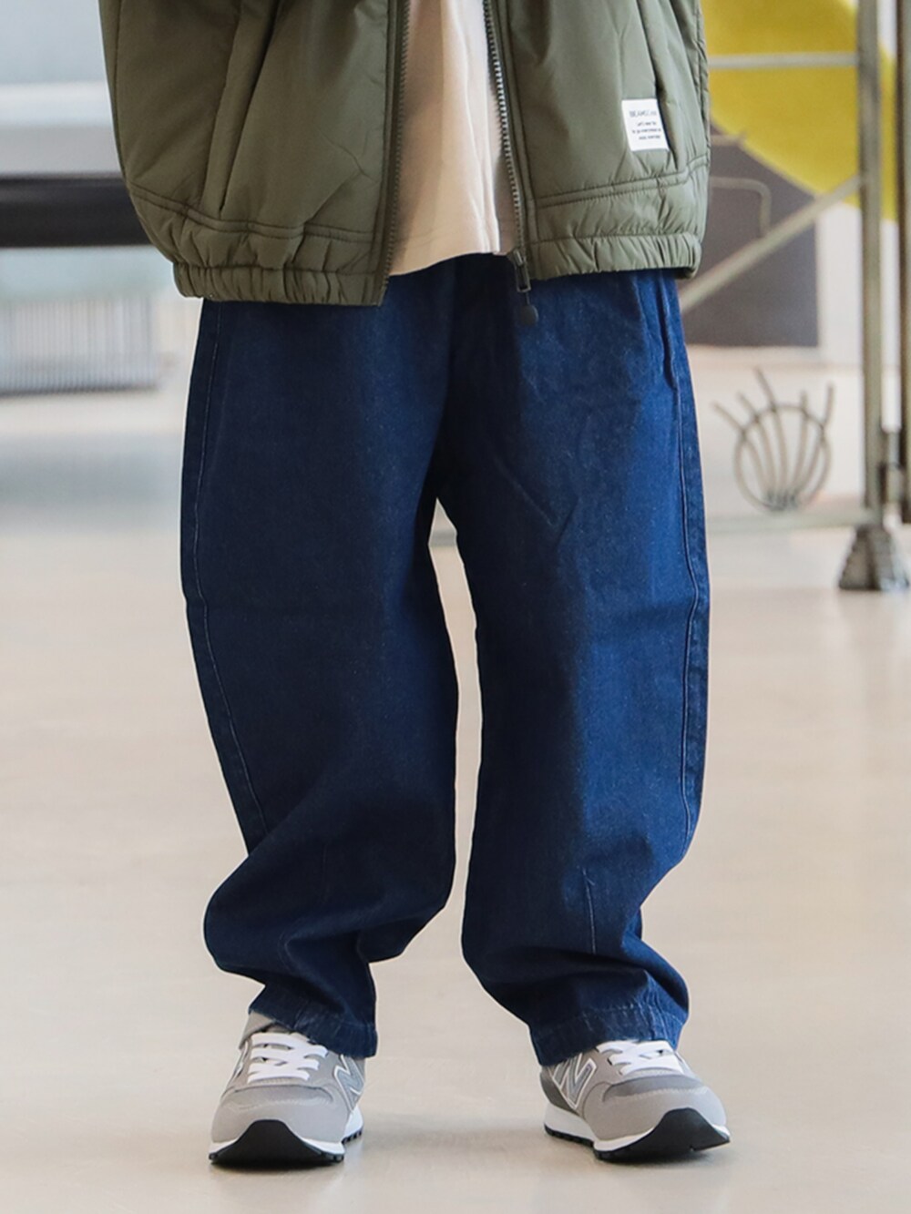 グリーン系のブルゾン、ブルー系のその他パンツ、ベージュ系のTシャツ/カットソーを着用したキッズの秋コーディネートの7枚目の写真