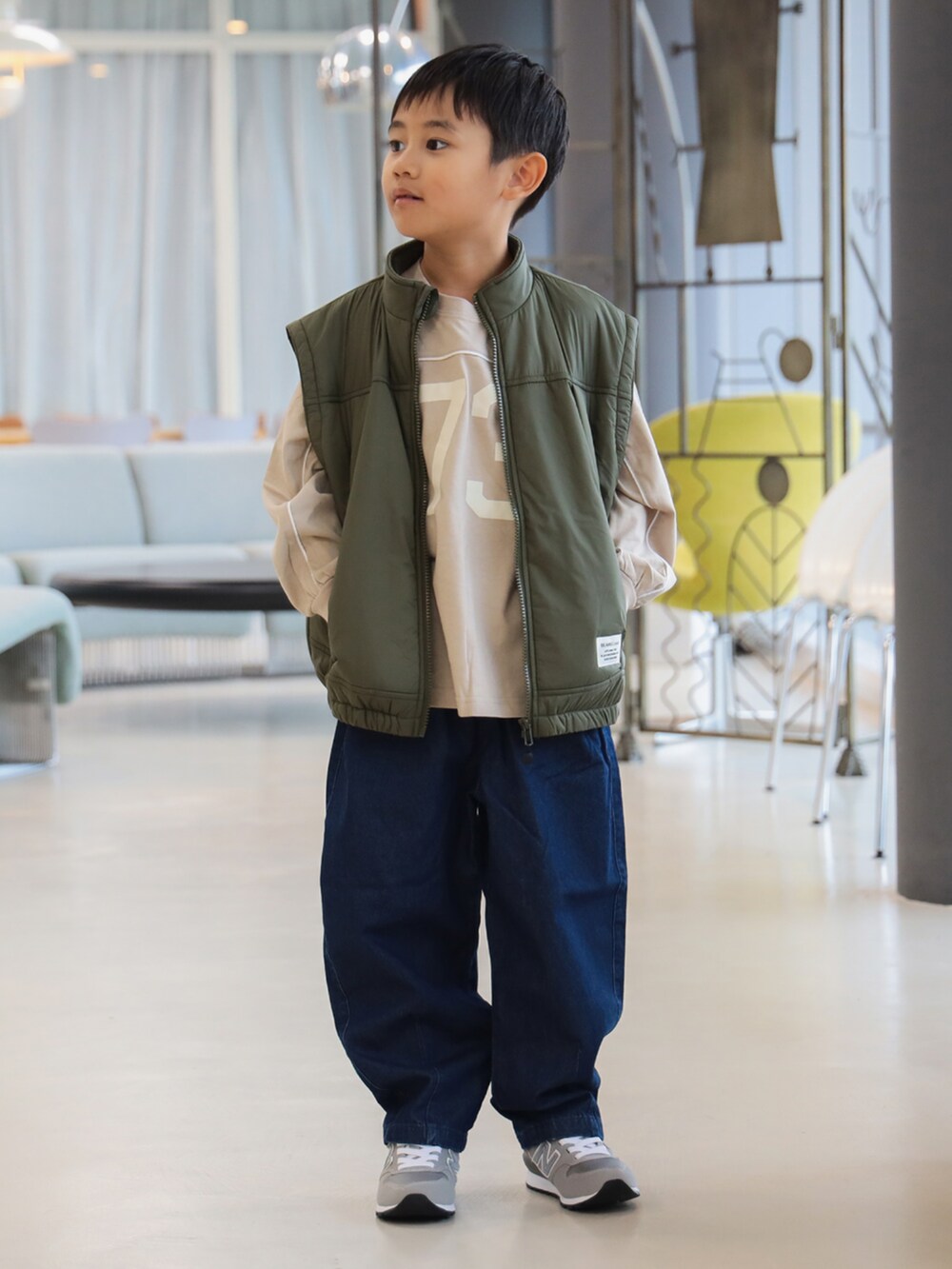 グリーン系のブルゾン、ブルー系のその他パンツ、ベージュ系のTシャツ/カットソーを着用したキッズの秋コーディネートの4枚目の写真