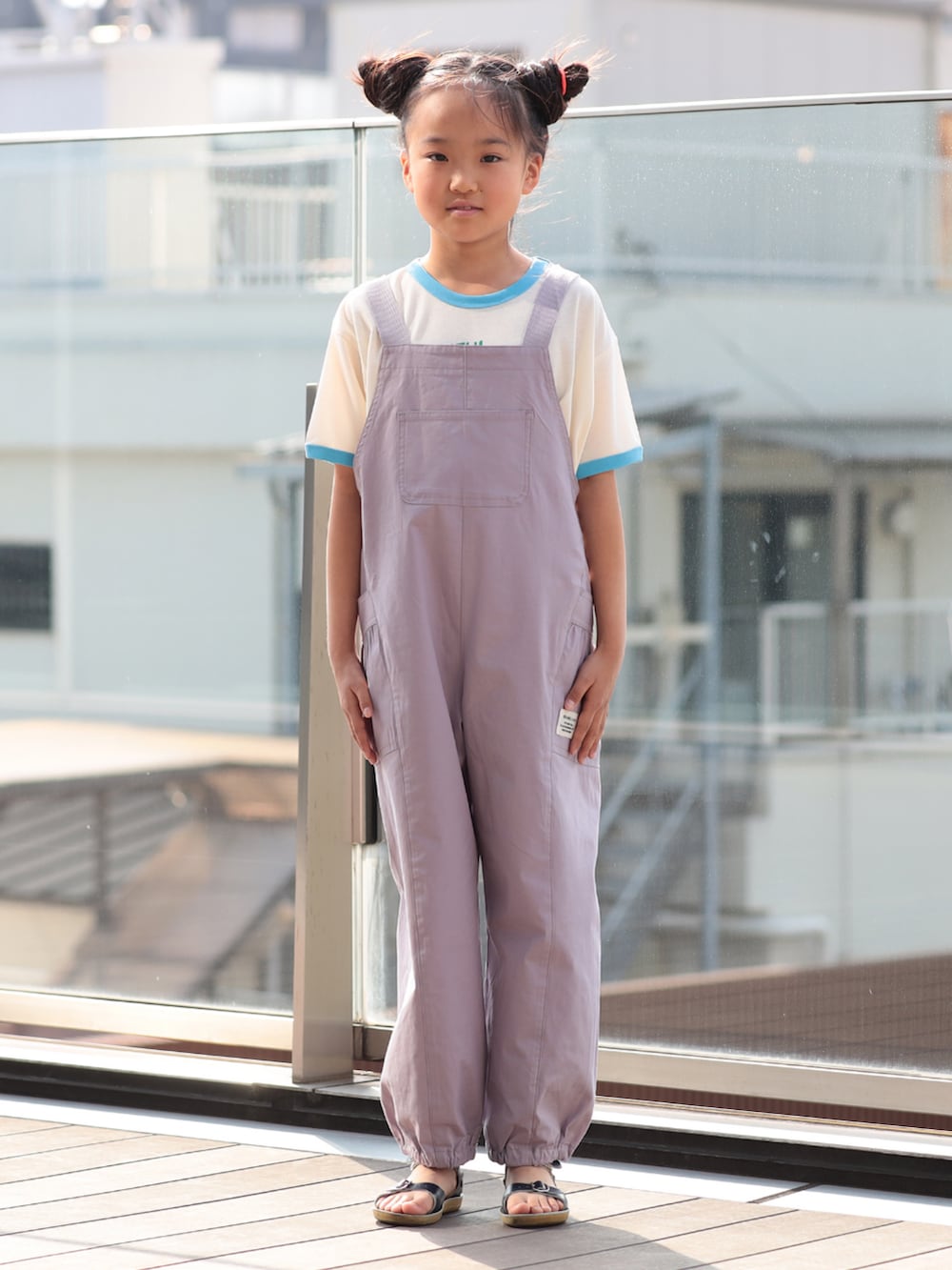 パープル系のサロペット/オーバーオール、ホワイト系のTシャツ/カットソーを着用したキッズの春コーディネートの2枚目の写真
