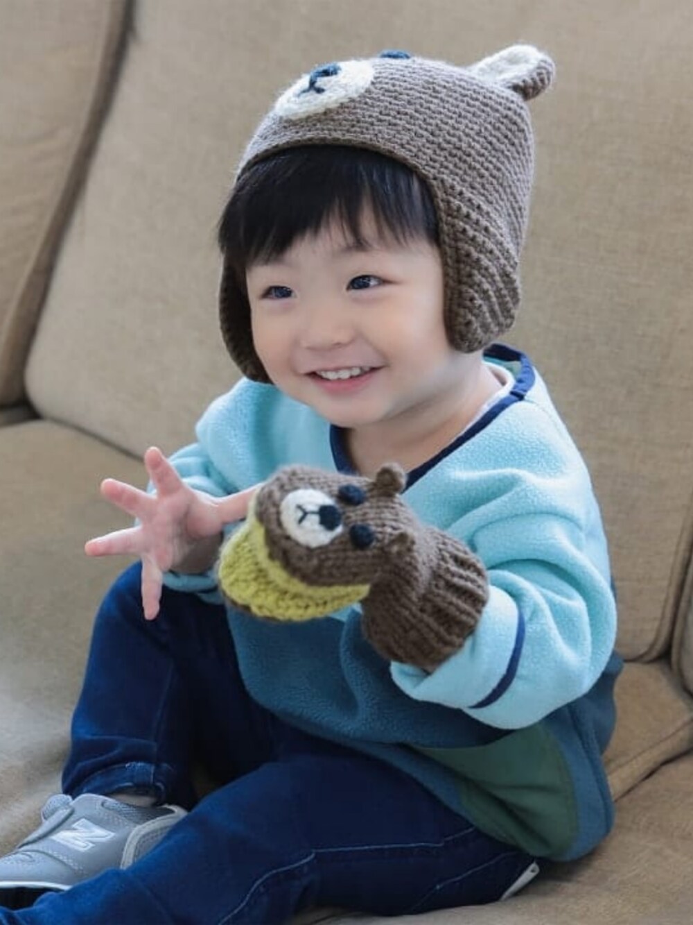 ブルー系のその他パンツ、グリーン系のスウェット、ブラウン系のニットキャップ/ビーニーを着用したキッズの冬コーディネートの2枚目の写真