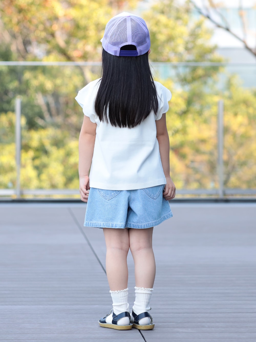 ブルー系のその他パンツ、ホワイト系のTシャツ/カットソー、パープル系のキャップを着用したキッズの春コーディネートの2枚目の写真