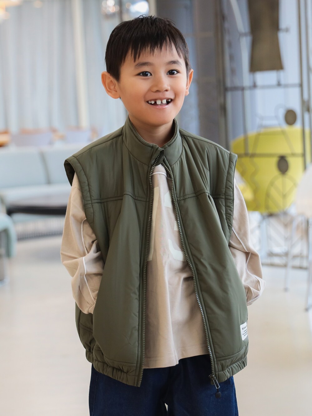グリーン系のブルゾン、ブルー系のその他パンツ、ベージュ系のTシャツ/カットソーを着用したキッズの秋コーディネートの5枚目の写真