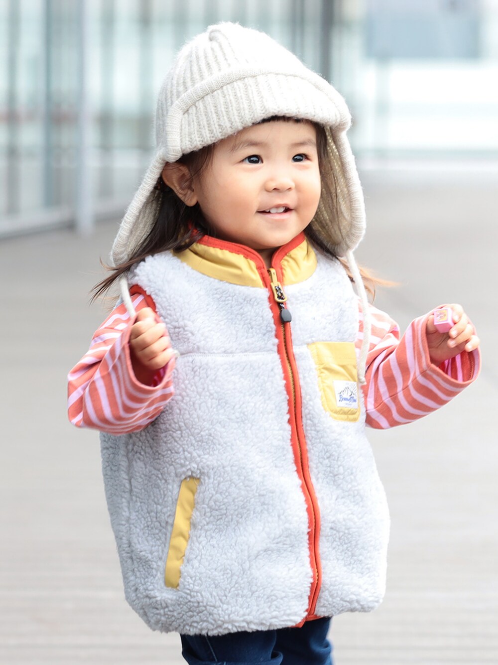 ベージュ系のベスト、ブルー系のその他パンツ、ピンク系のTシャツ/カットソーを着用したキッズの冬コーディネートの3枚目の写真