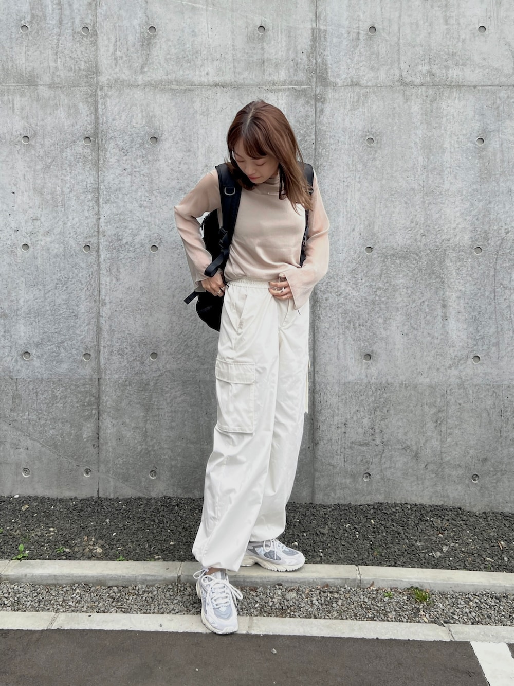 ホワイト系のカーゴパンツ、ベージュ系のTシャツ/カットソー、ブラック系のバックパック/リュックを着用したレディースの春コーディネートの3枚目の写真