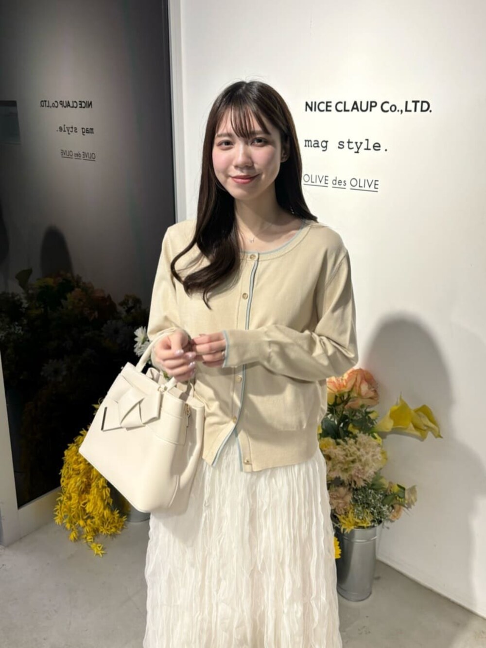 ホワイト系のサンダル、ベージュ系のカーディガン/ボレロ、ホワイト系のスカートを着用したレディースの冬コーディネートの6枚目の写真