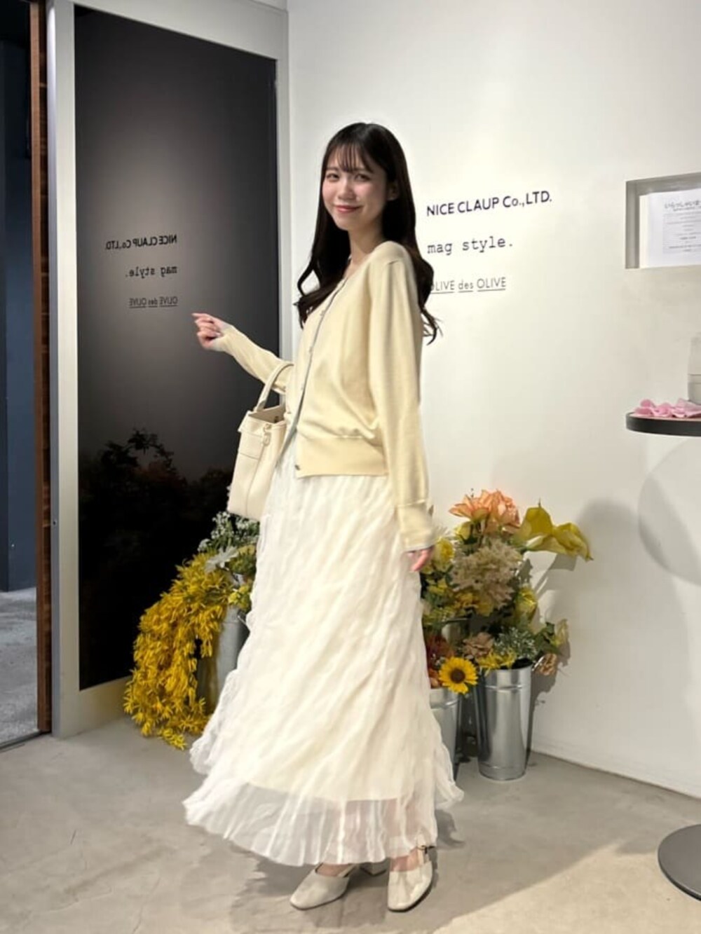 ホワイト系のサンダル、ベージュ系のカーディガン/ボレロ、ホワイト系のスカートを着用したレディースの冬コーディネートの3枚目の写真