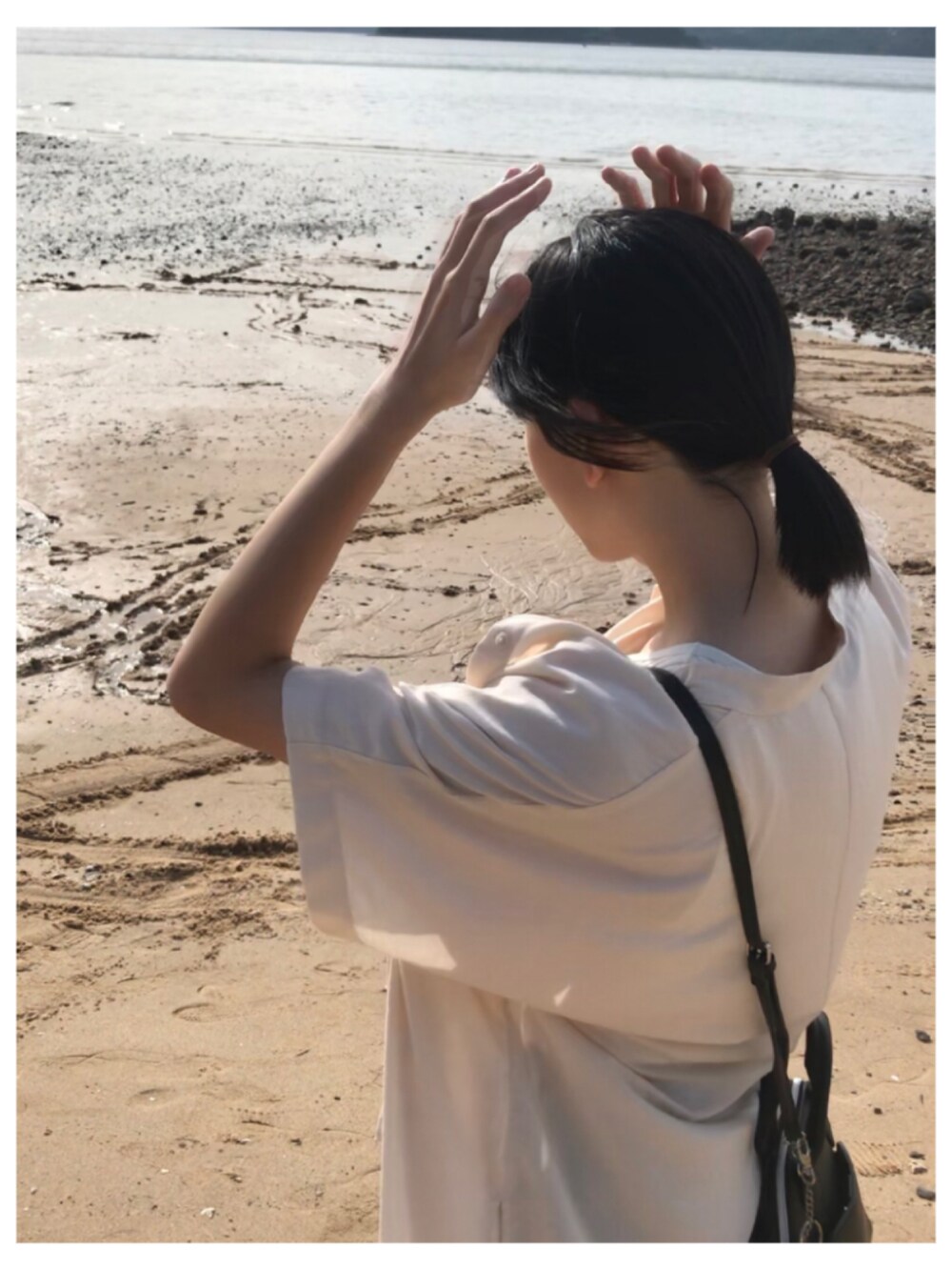 ホワイト系のシャツ/ブラウス、ブルー系のデニムパンツ、ブラック系のショルダーバッグを着用したレディースの夏コーディネートの3枚目の写真