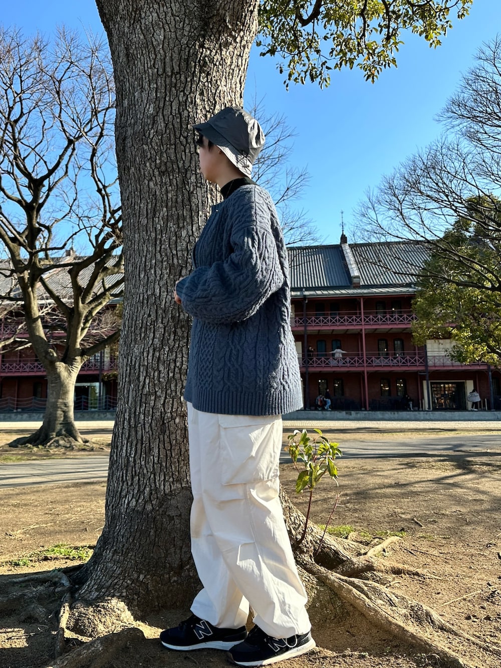 ブルー系のニット/セーター、ホワイト系のパンツ、グレー系のハットを着用したレディースの春コーディネートの2枚目の写真