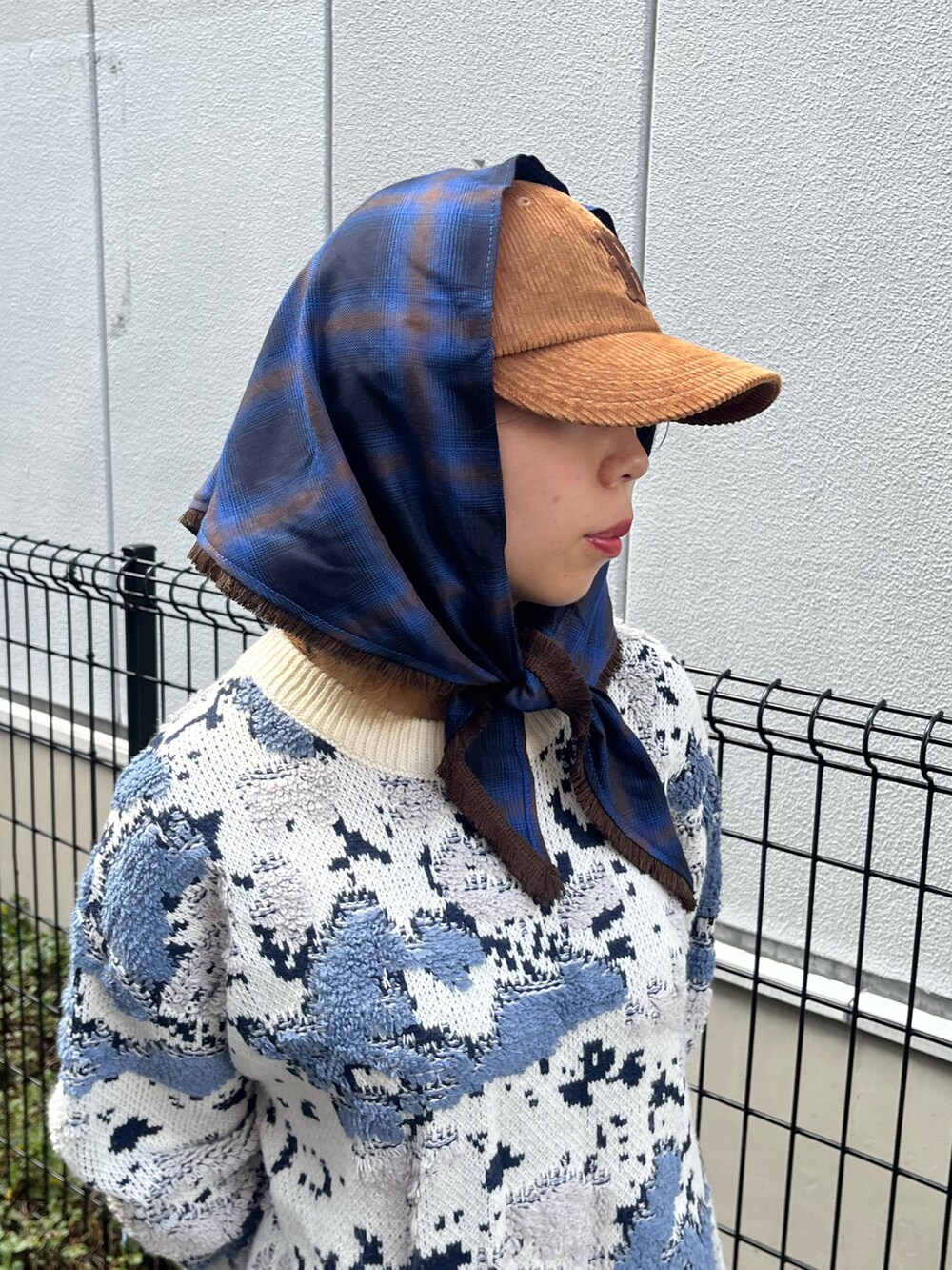 ホワイト系のニット/セーター、ブラウン系のキャップを着用したレディースの秋コーディネートの2枚目の写真