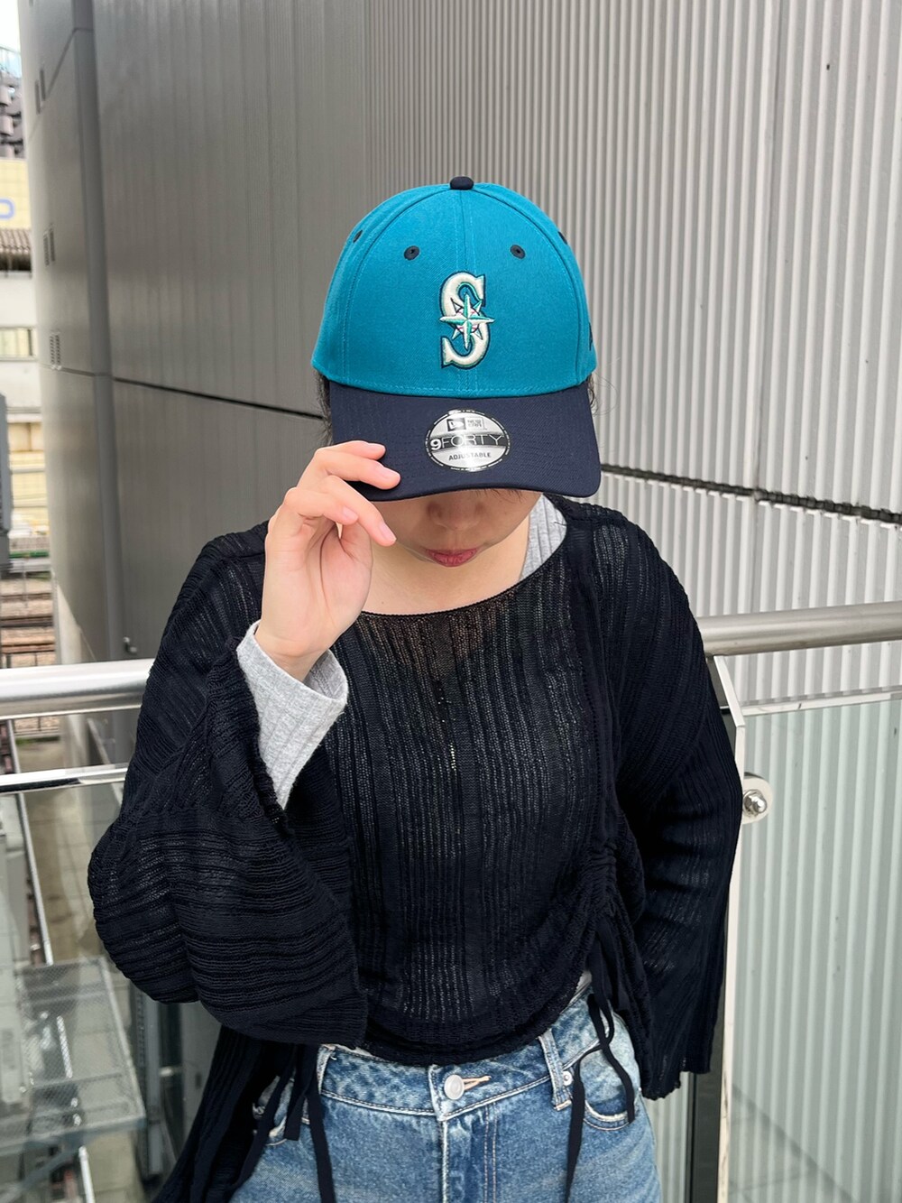 ブルー系のデニムパンツ、ブルー系のキャップを着用したレディースの秋コーディネートの2枚目の写真