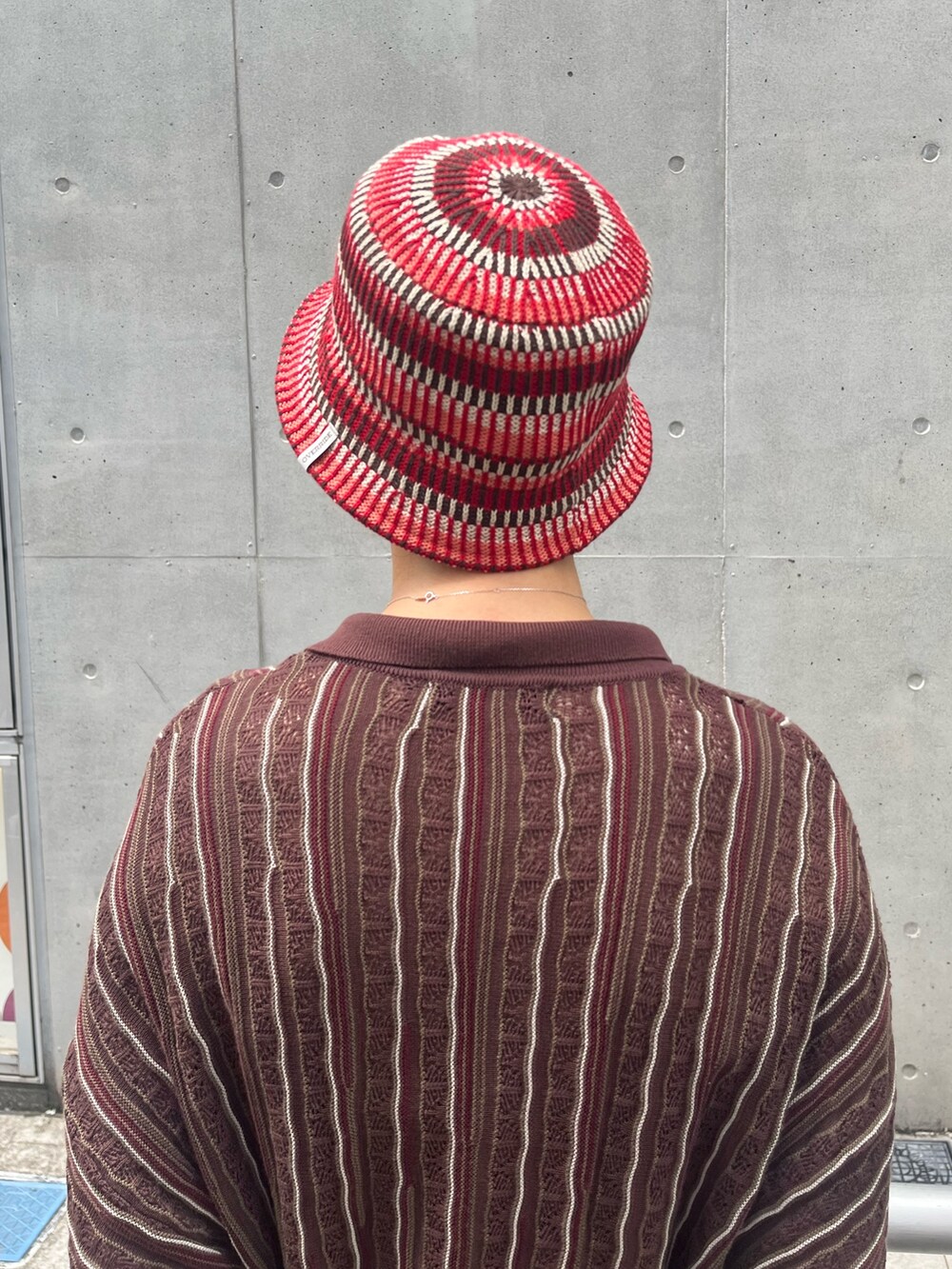 ブラック系のトップス、レッド系のハットを着用したレディースの秋コーディネートの3枚目の写真