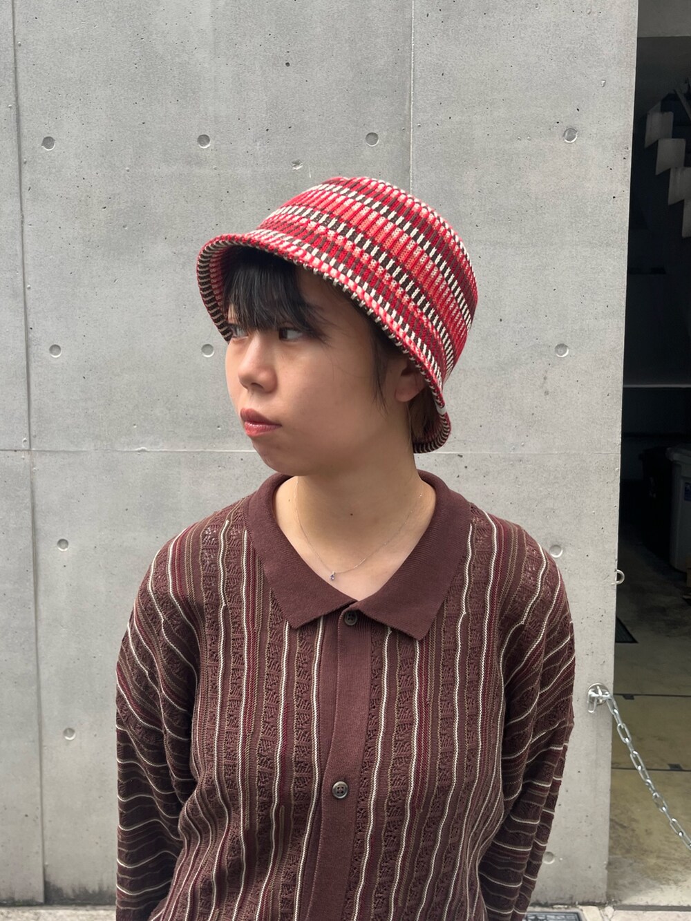 ブラック系のトップス、レッド系のハットを着用したレディースの秋コーディネートの2枚目の写真