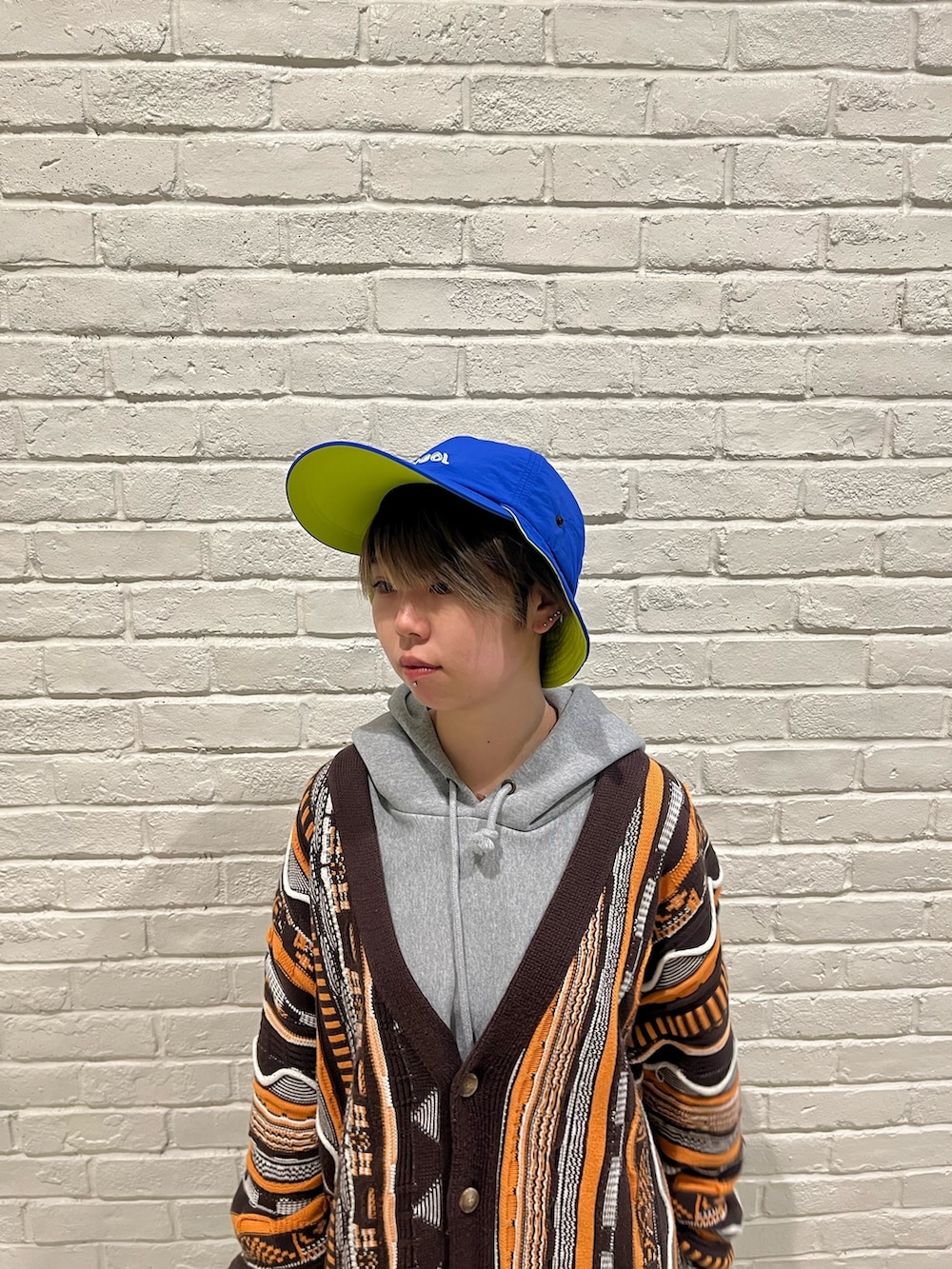 ベージュ系のパンツ、ブラック系のスニーカー、ブルー系のキャップを着用したレディースの春コーディネートの2枚目の写真