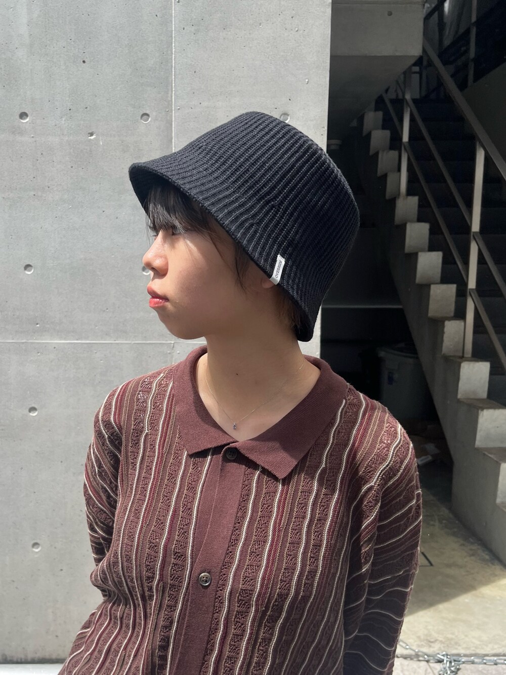 ブラック系のトップス、レッド系のハットを着用したレディースの秋コーディネートの5枚目の写真