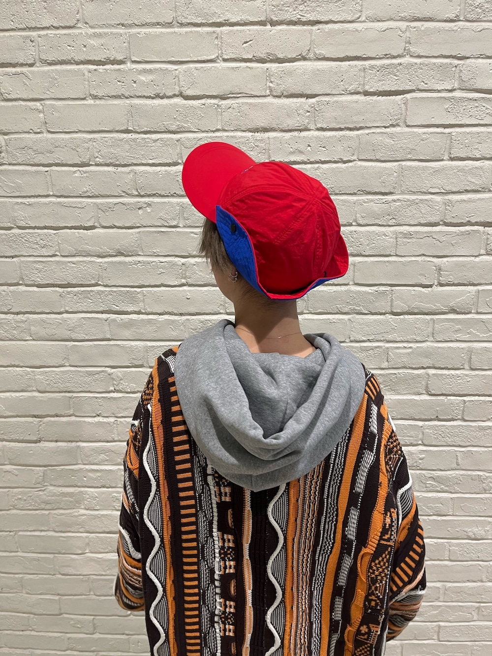 ベージュ系のパンツ、ブラック系のスニーカー、ブルー系のキャップを着用したレディースの春コーディネートの6枚目の写真