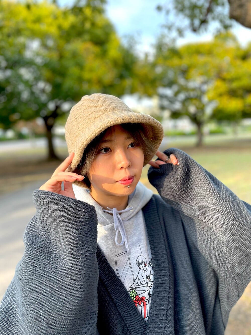 グレー系のカーディガン/ボレロ、ブラウン系のチノパンツ、ブラック系のスニーカーを着用したレディースの秋コーディネートの3枚目の写真