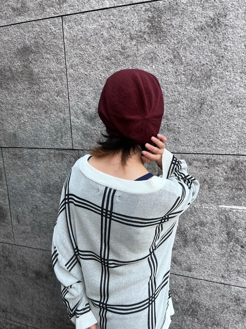 レッド系のニットキャップ/ビーニーを着用したレディースの秋コーディネートの2枚目の写真