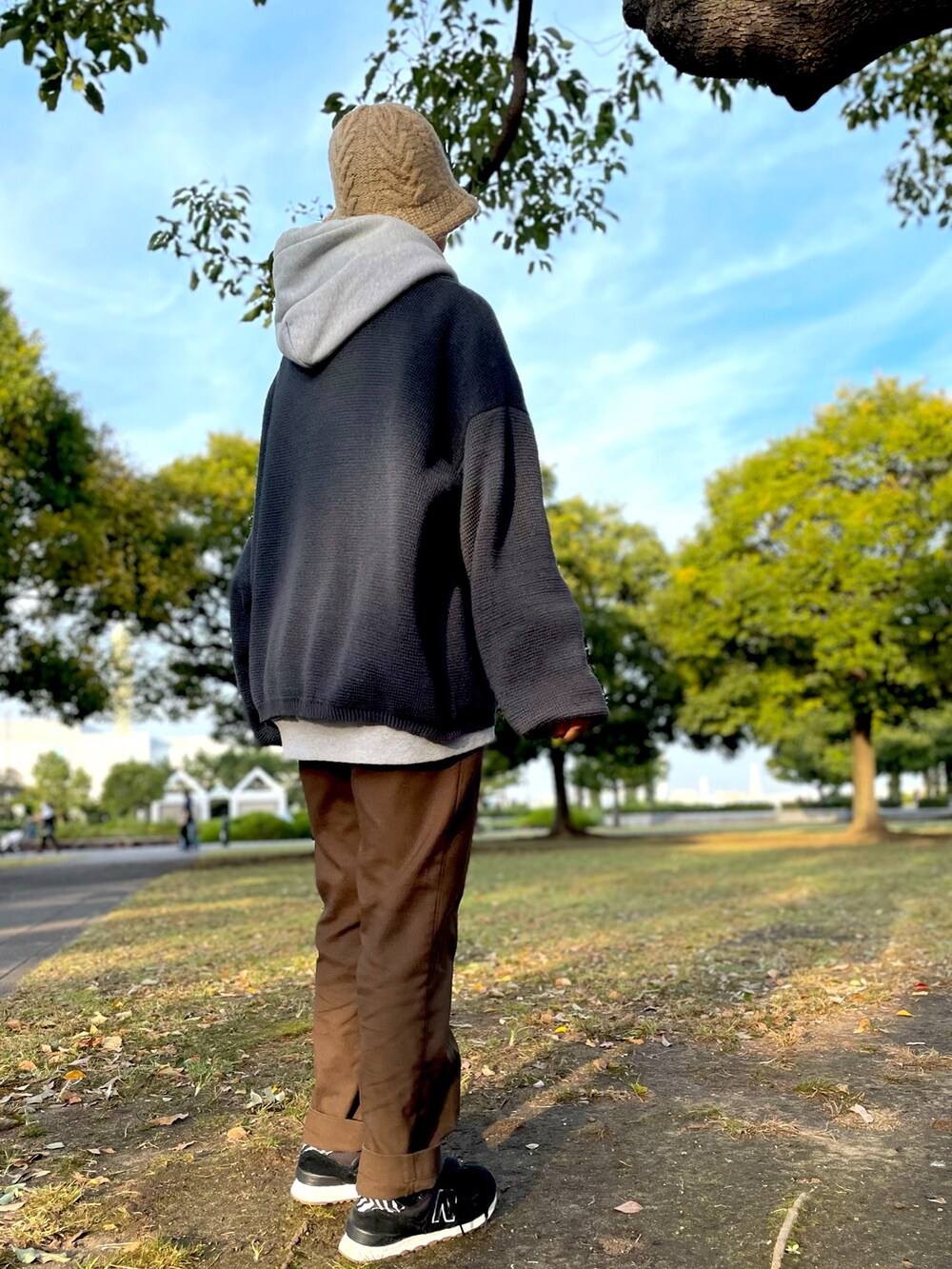 グレー系のカーディガン/ボレロ、ブラウン系のチノパンツ、ブラック系のスニーカーを着用したレディースの秋コーディネートの2枚目の写真