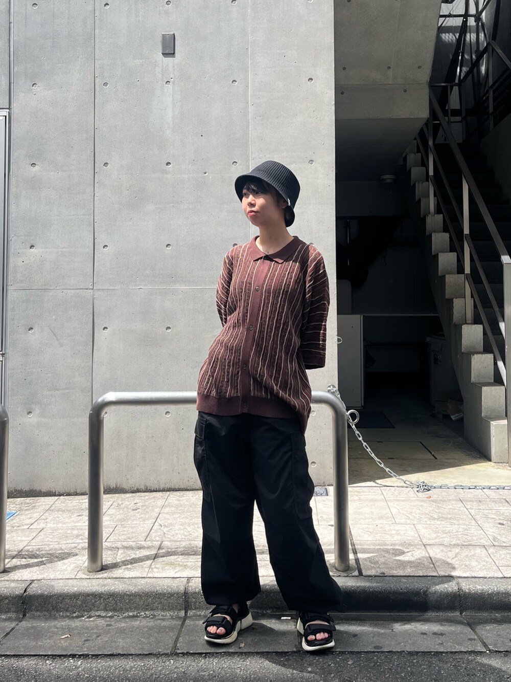 ブラック系のトップス、レッド系のハットを着用したレディースの秋コーディネートの4枚目の写真