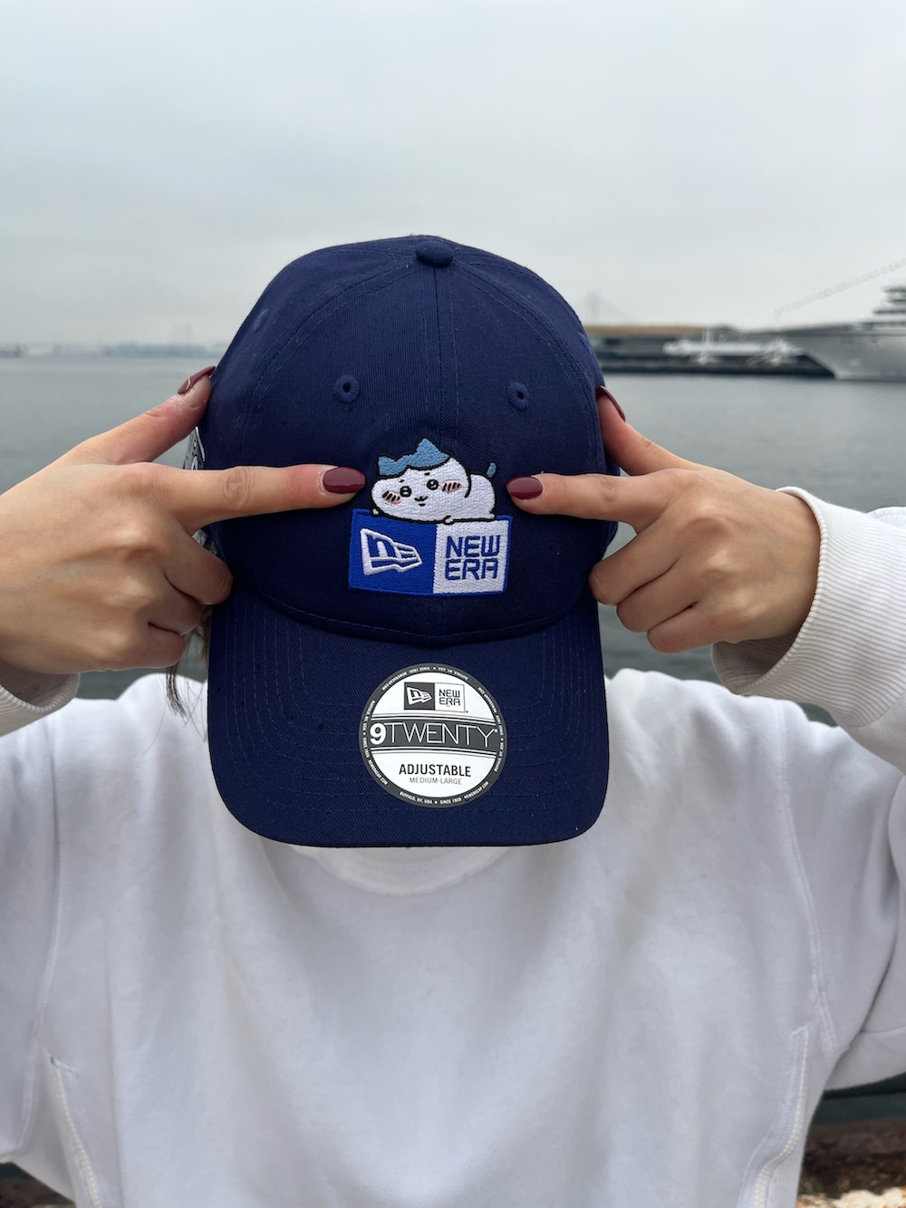 ブルー系のキャップを着用したレディースの春コーディネートの2枚目の写真