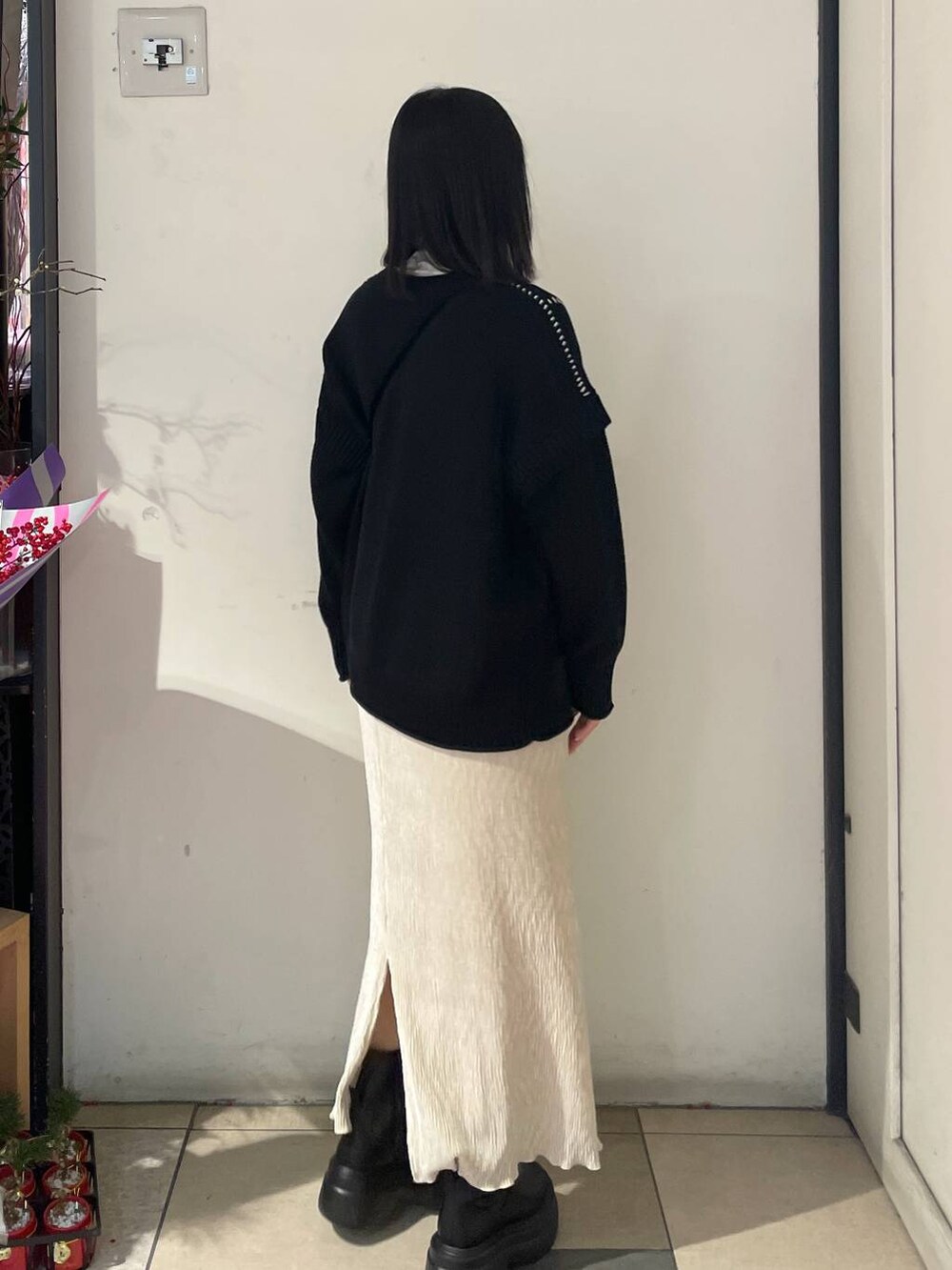 ブラック系のTシャツ/カットソー、ブラック系のブーツ、ブラック系のハンドバッグを着用したレディースの冬コーディネートの3枚目の写真