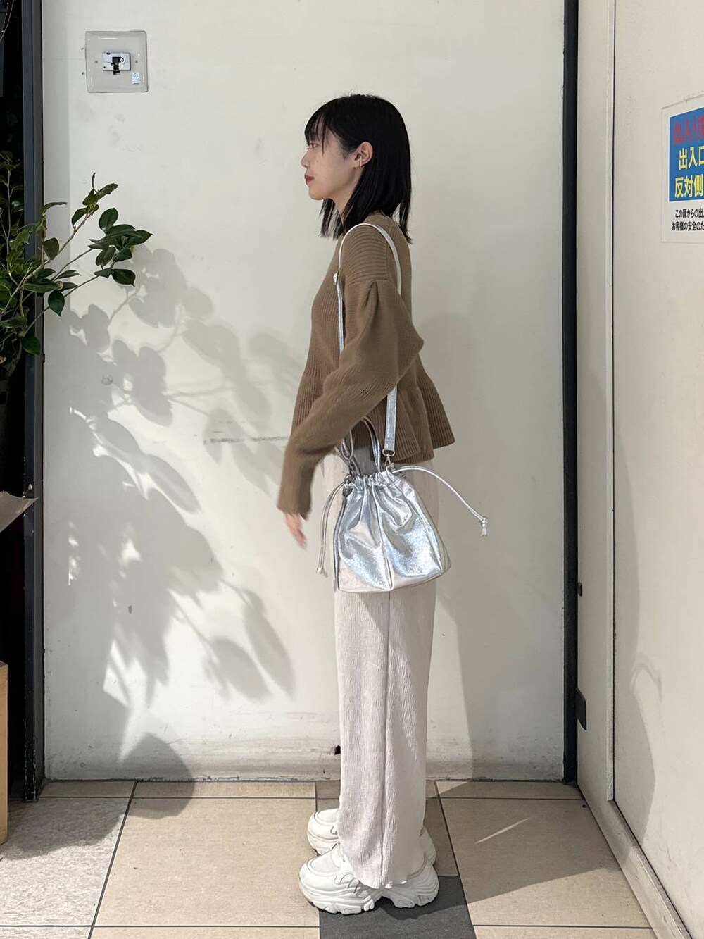 ホワイト系のその他パンツ、ベージュ系のニット/セーター、ホワイト系のスニーカーを着用したレディースの冬コーディネートの2枚目の写真