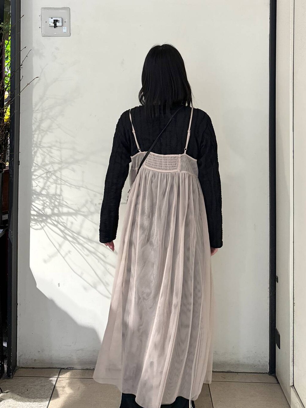 ブラック系のパンプス、ベージュ系のワンピース、ブラック系のショルダーバッグを着用したレディースの冬コーディネートの3枚目の写真