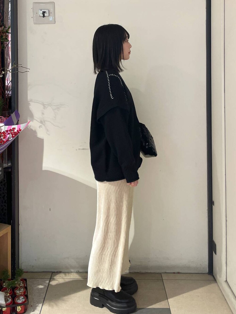 ブラック系のTシャツ/カットソー、ブラック系のブーツ、ブラック系のハンドバッグを着用したレディースの冬コーディネートの4枚目の写真