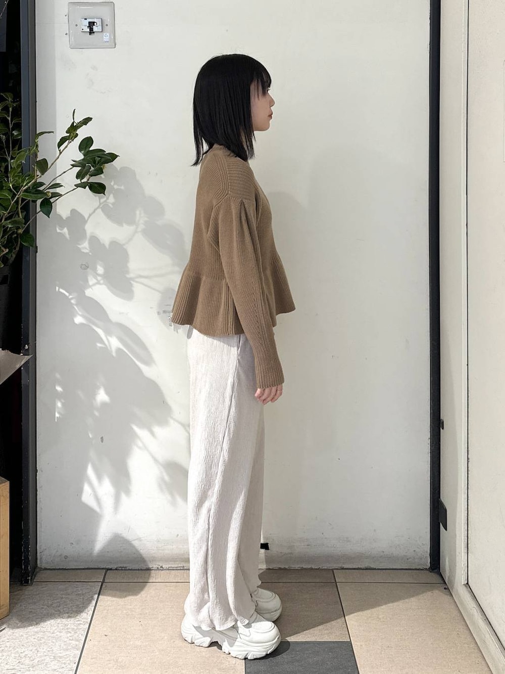 ホワイト系のその他パンツ、ベージュ系のニット/セーター、ホワイト系のスニーカーを着用したレディースの冬コーディネートの3枚目の写真