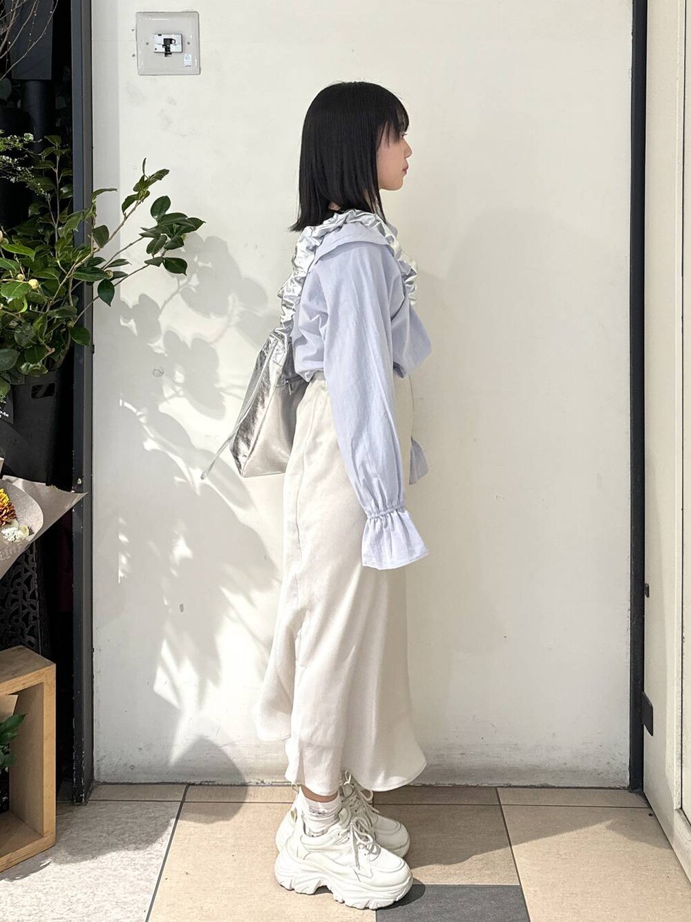 グレー系のトートバッグ、ブルー系のシャツ/ブラウス、ホワイト系のスカートを着用したレディースの冬コーディネートの3枚目の写真