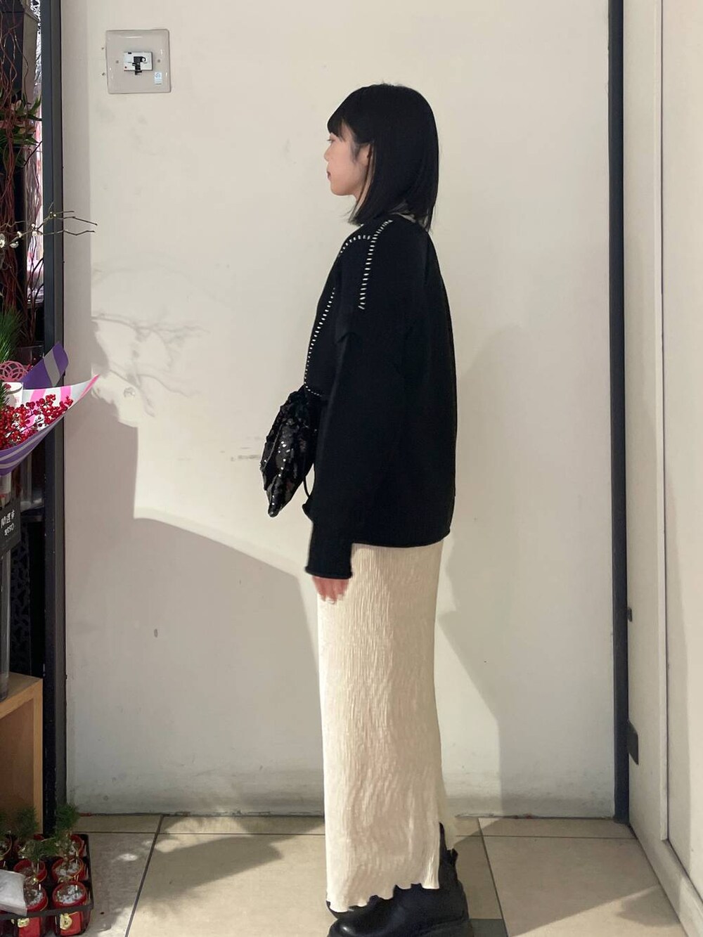 ブラック系のTシャツ/カットソー、ブラック系のブーツ、ブラック系のハンドバッグを着用したレディースの冬コーディネートの2枚目の写真