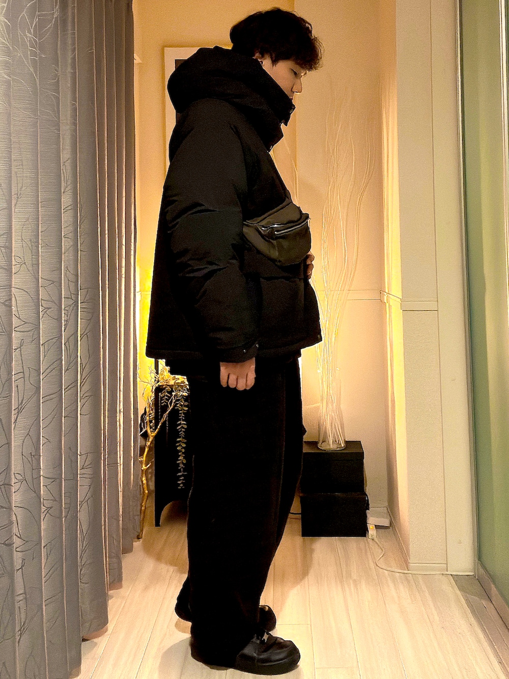 ブラック系のダウンジャケット/コート、グレー系のボディバッグ/ウエストポーチ、ブラウン系のカーゴパンツを着用したメンズの秋コーディネートの2枚目の写真