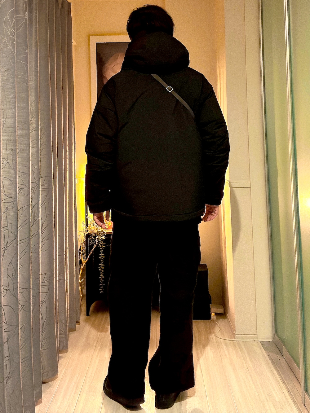 ブラック系のダウンジャケット/コート、グレー系のボディバッグ/ウエストポーチ、ブラウン系のカーゴパンツを着用したメンズの秋コーディネートの3枚目の写真