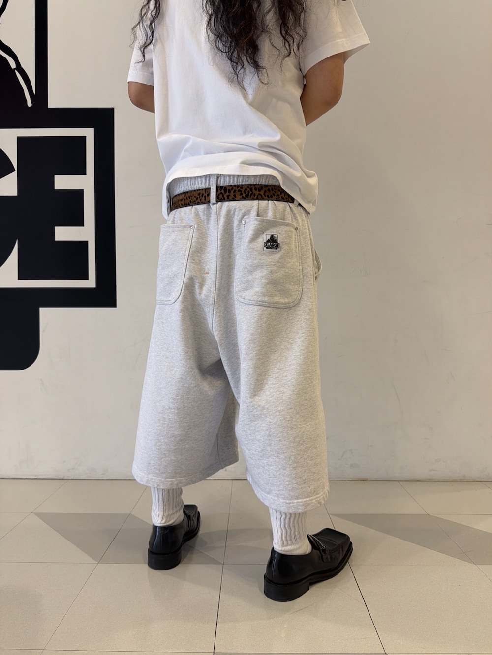 ホワイト系のTシャツ/カットソー、グレー系のスウェットパンツ、レッド系のキャップを着用したメンズの夏コーディネートの3枚目の写真