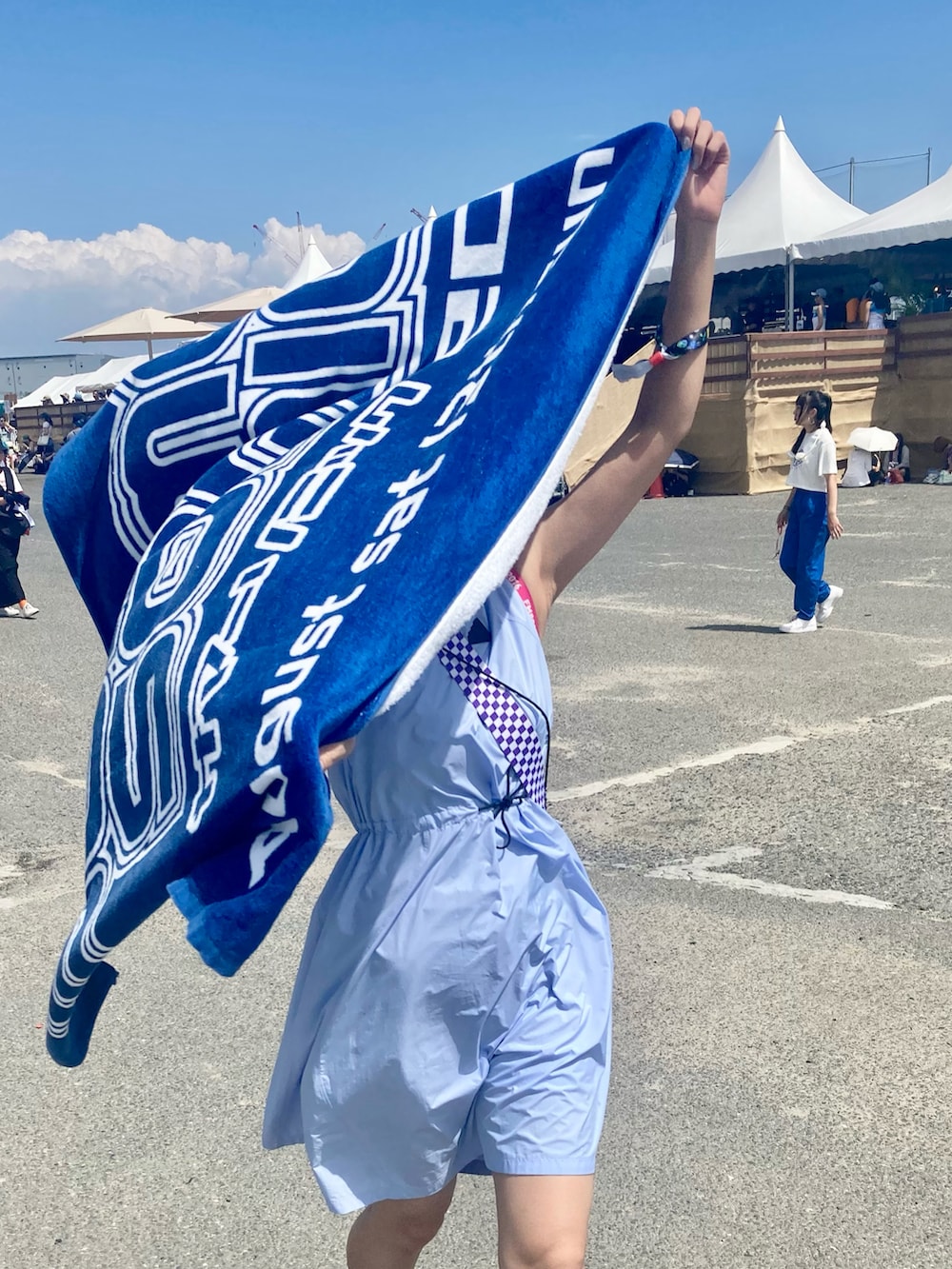 ブラック系のスニーカー、オレンジ系のショルダーバッグ、ブルー系のワンピース/ドレスを着用したレディースの秋コーディネートの2枚目の写真