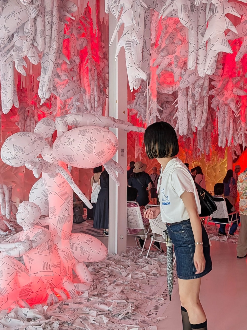 ブラック系のスニーカー、ホワイト系のTシャツ/カットソー、ブルー系のデニムスカートを着用したレディースの夏コーディネートの3枚目の写真