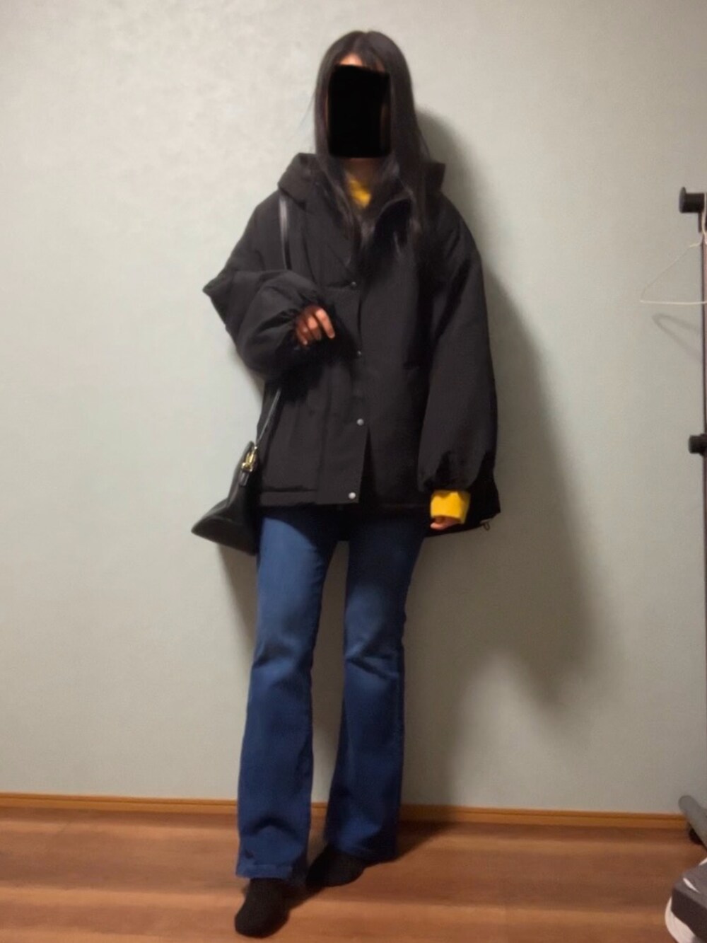 ブラック系のダウンジャケット/コート、イエロー系のニット/セーター、ホワイト系のTシャツ/カットソーを着用したレディースの冬コーディネートの4枚目の写真