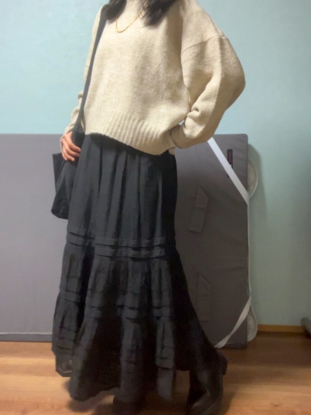 ベージュ系のニット/セーター、ブラック系のショルダーバッグ、ブラック系のスカートを着用したレディースの春コーディネートの2枚目の写真