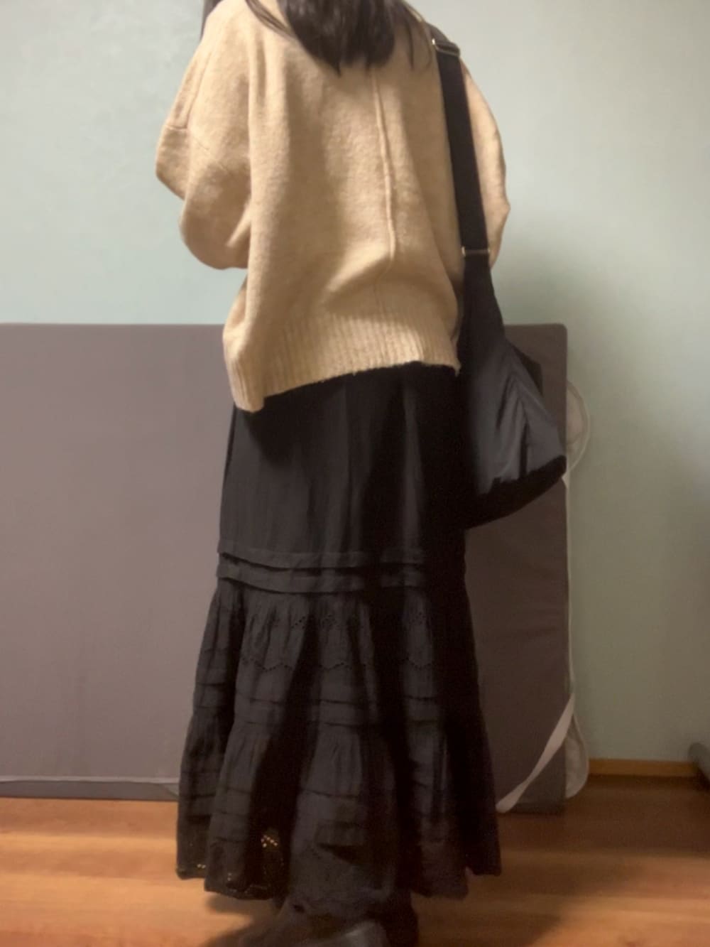 ベージュ系のニット/セーター、ブラック系のショルダーバッグ、ブラック系のスカートを着用したレディースの春コーディネートの3枚目の写真