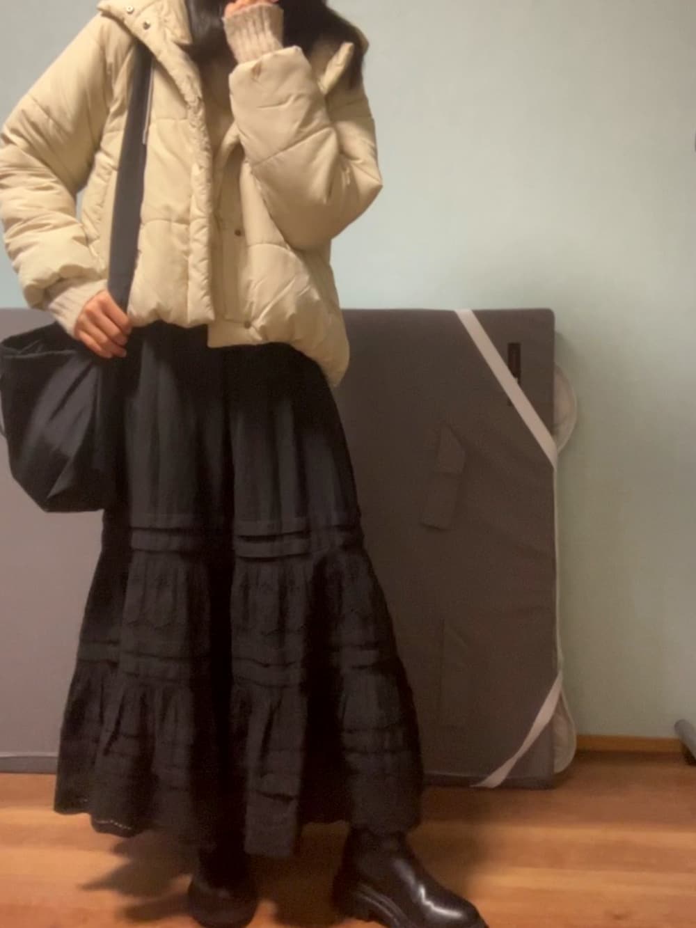 ベージュ系のニット/セーター、ブラック系のショルダーバッグ、ブラック系のスカートを着用したレディースの春コーディネートの4枚目の写真