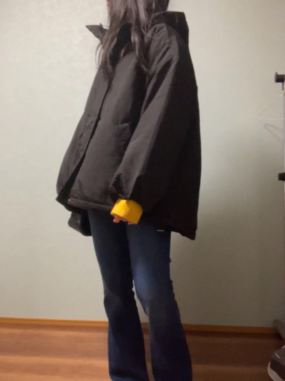 ブラック系のダウンジャケット/コート、イエロー系のニット/セーター、ホワイト系のTシャツ/カットソーを着用したレディースの冬コーディネートの3枚目の写真