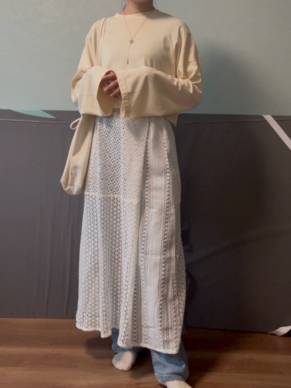 ホワイト系のスカート、ブルー系のデニムパンツ、ベージュ系のTシャツ/カットソーを着用したレディースの春コーディネートの2枚目の写真