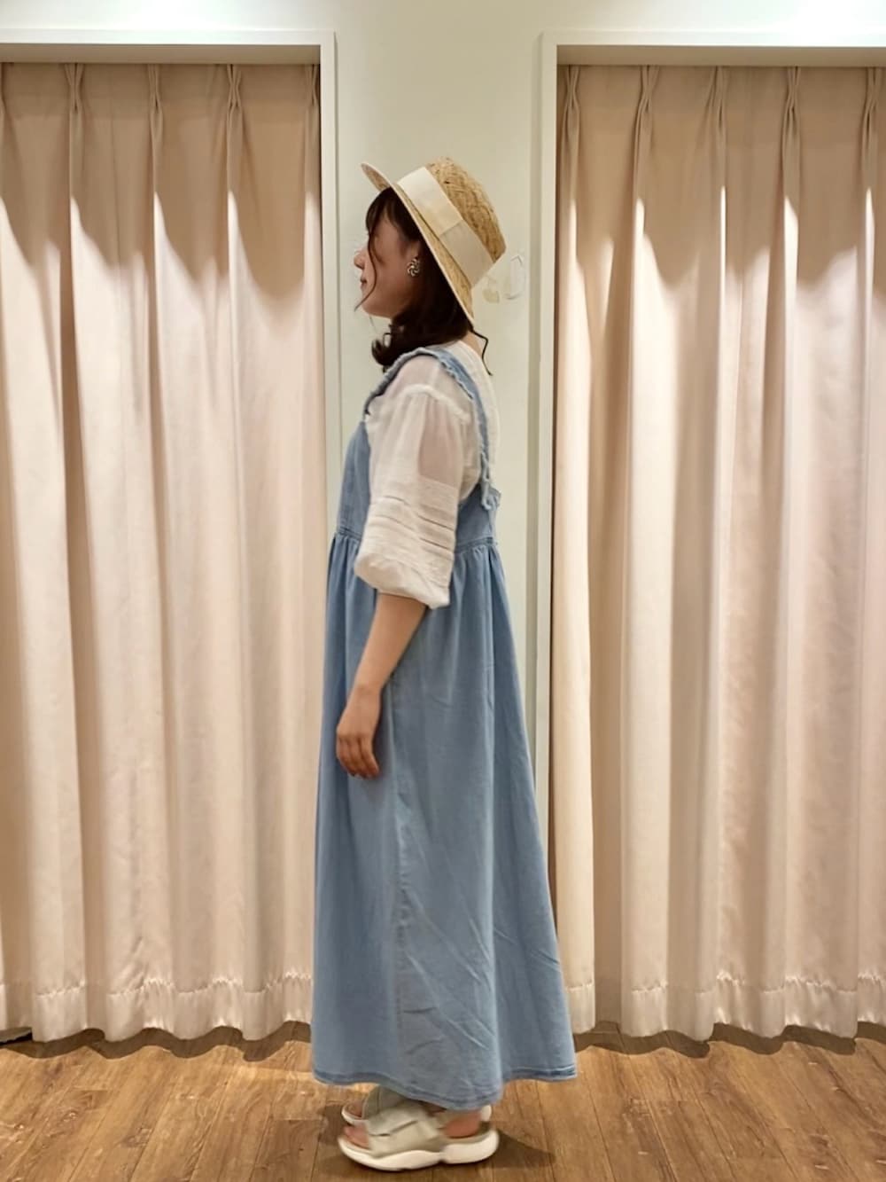 ホワイト系のチュニック、ブルー系のワンピース/ドレス、ベージュ系のサンダルを着用したレディースの春コーディネートの2枚目の写真