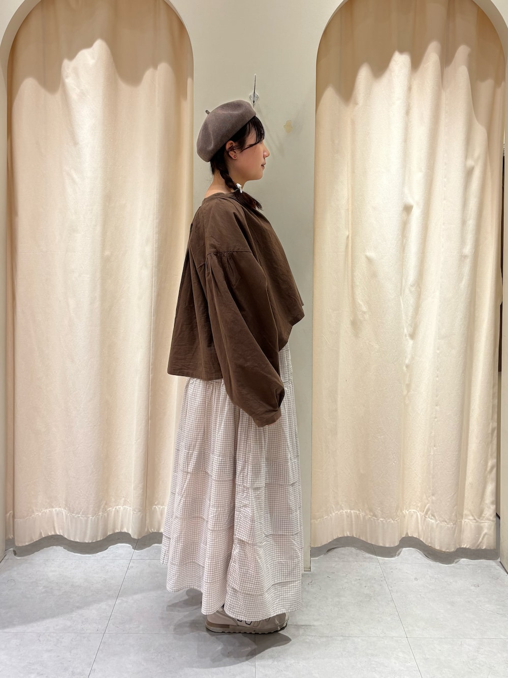 ブラウン系のノーカラージャケット、ベージュ系のスカート、ブラウン系のハットを着用したレディースの冬コーディネートの3枚目の写真