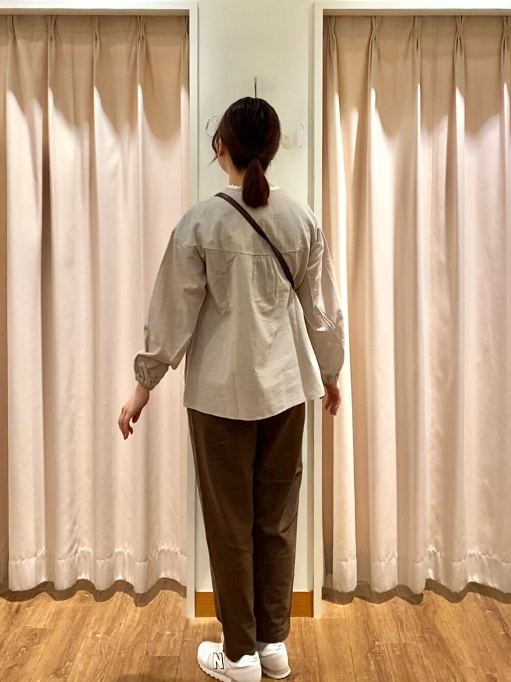 オレンジ系のハンドバッグ、ベージュ系のシャツ/ブラウス、ブラウン系のその他パンツを着用したレディースの秋コーディネートの2枚目の写真